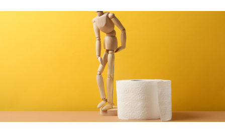 Boneco articulado de madeira junto a um rolo de papel higiênico