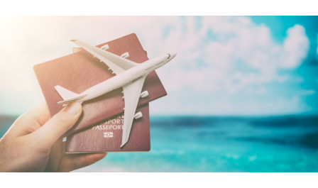 Passaportes em mãos junto com um avião em miniatura, com mar azul ao fundo